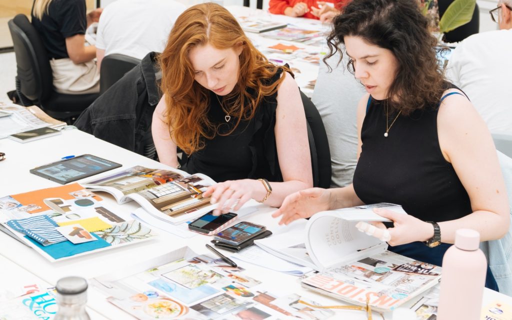 Students browsing magazines and samples at an interior decoration workshop