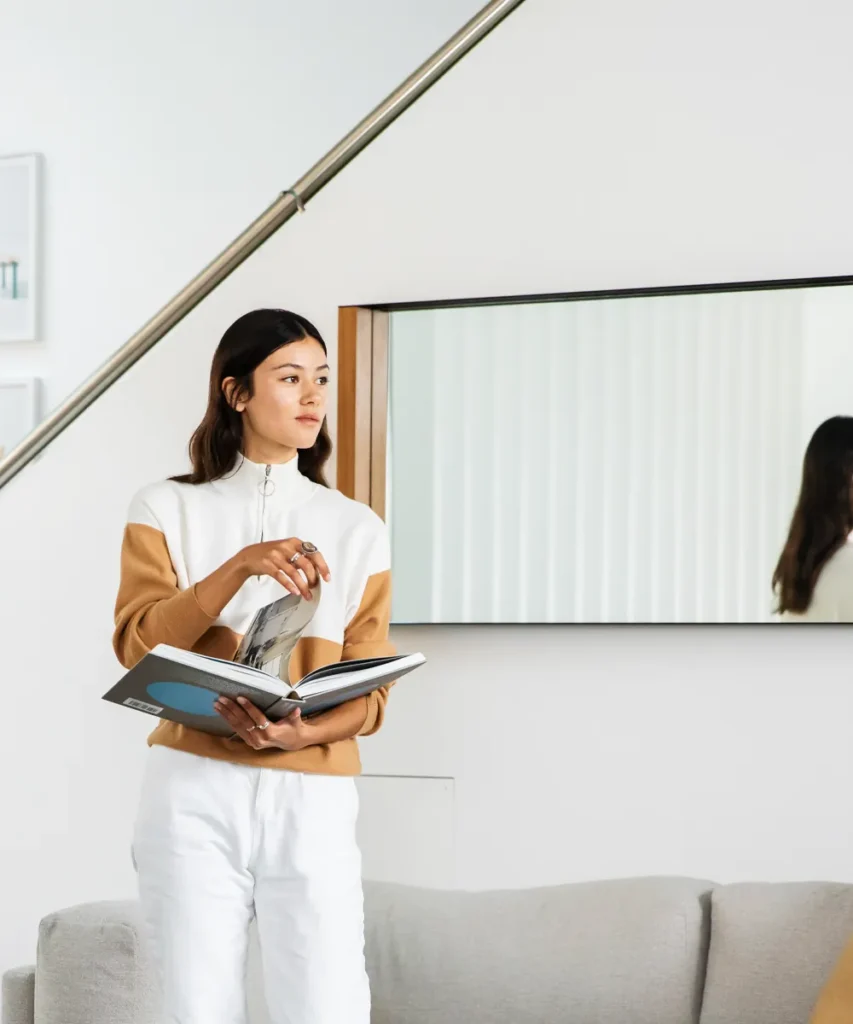 Advanced Diploma of Interior Design student reading a design book in a modern interior